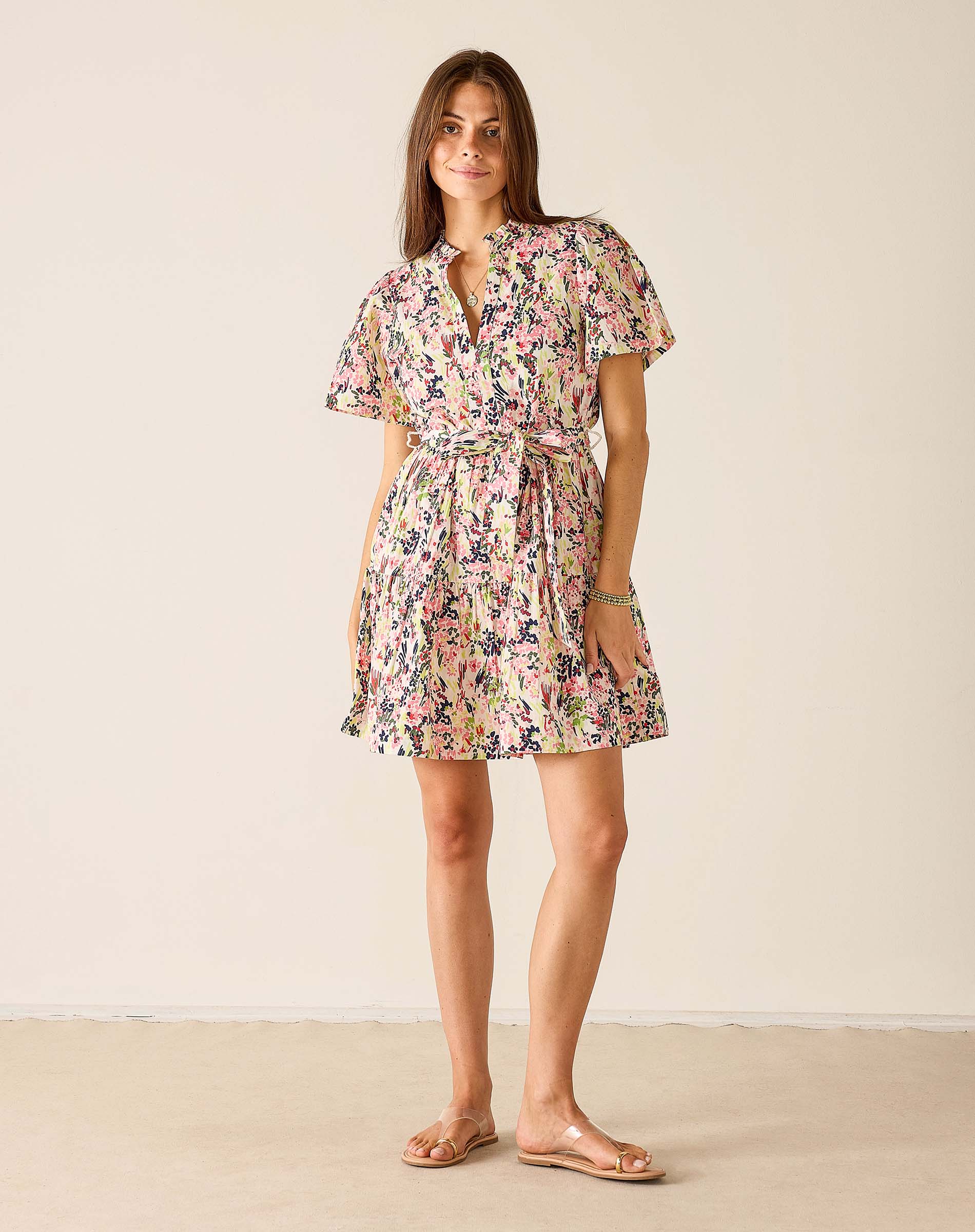 Woman wearing a floral dress against a plain background