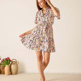 Woman wearing a floral dress standing in a room with a light background