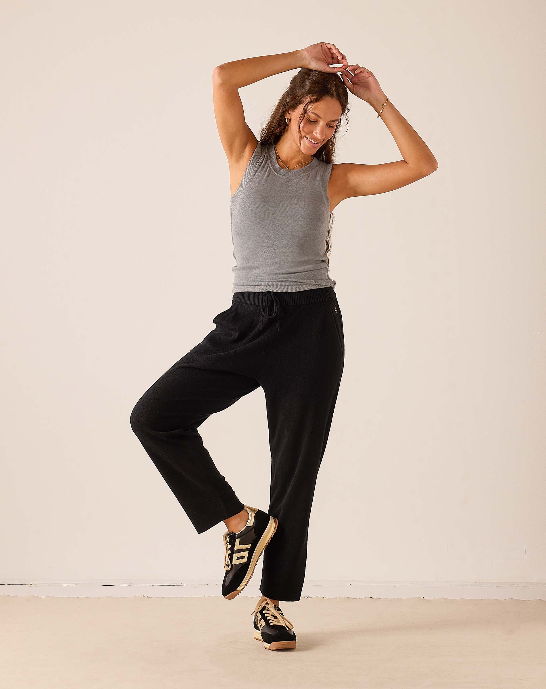 Black cashmere tapered pant with an elastic drawstring waist and a matching grey ribbed tank top.