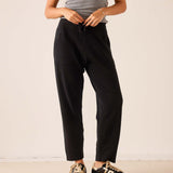 Black tapered cashmere pants with an elastic drawstring waist and relaxed fit.