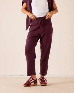 Plum cashmere tapered pant with an elastic waistband and drawstring detail.