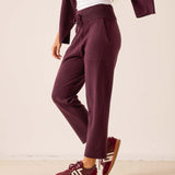 Plum color tapered fit cashmere pants featuring a soft knit feel and an elasticized waistband.