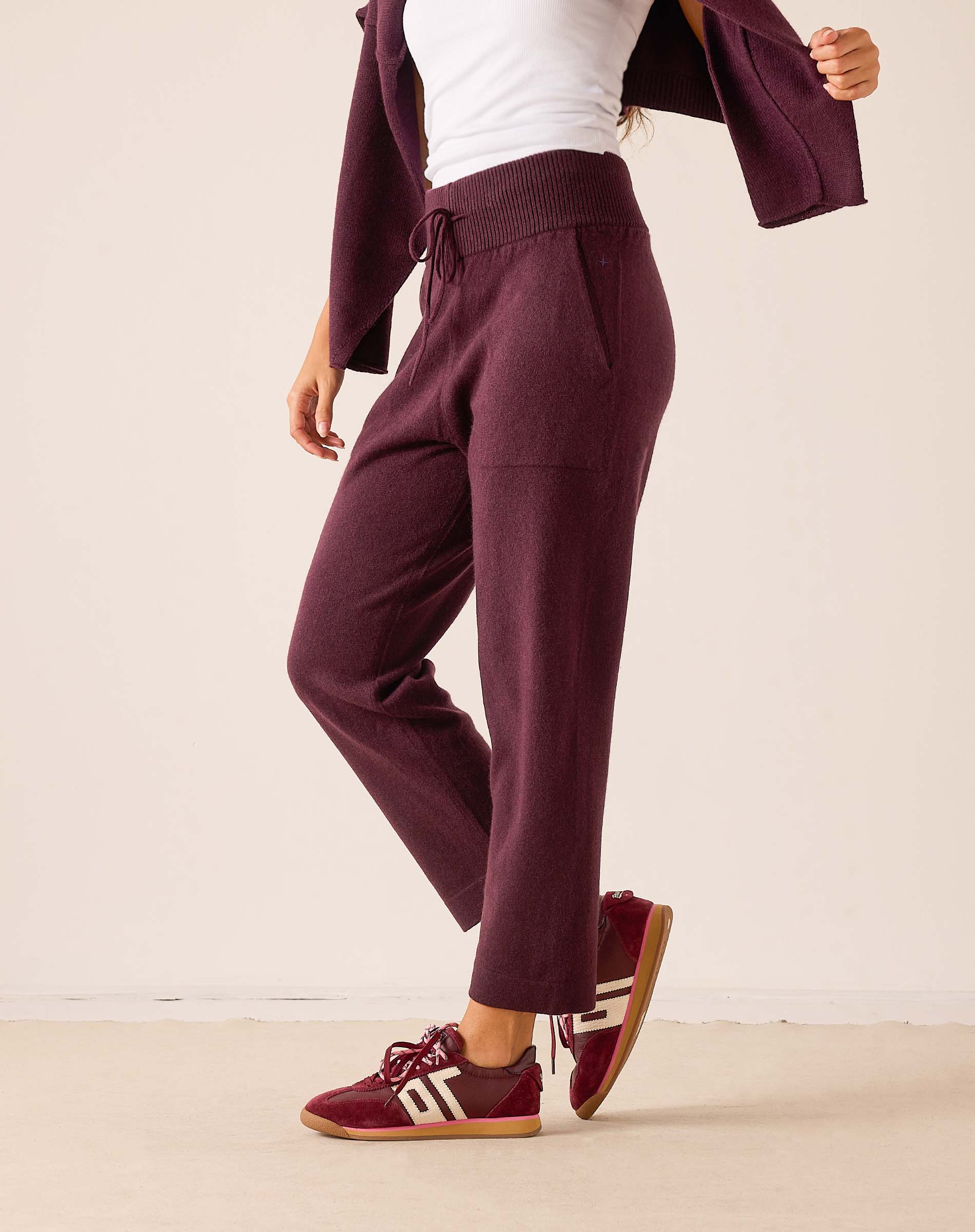 Plum color tapered fit cashmere pants featuring a soft knit feel and an elasticized waistband.