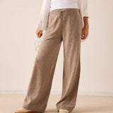 Beige wide-leg cashmere knit trousers with a drawstring waist.