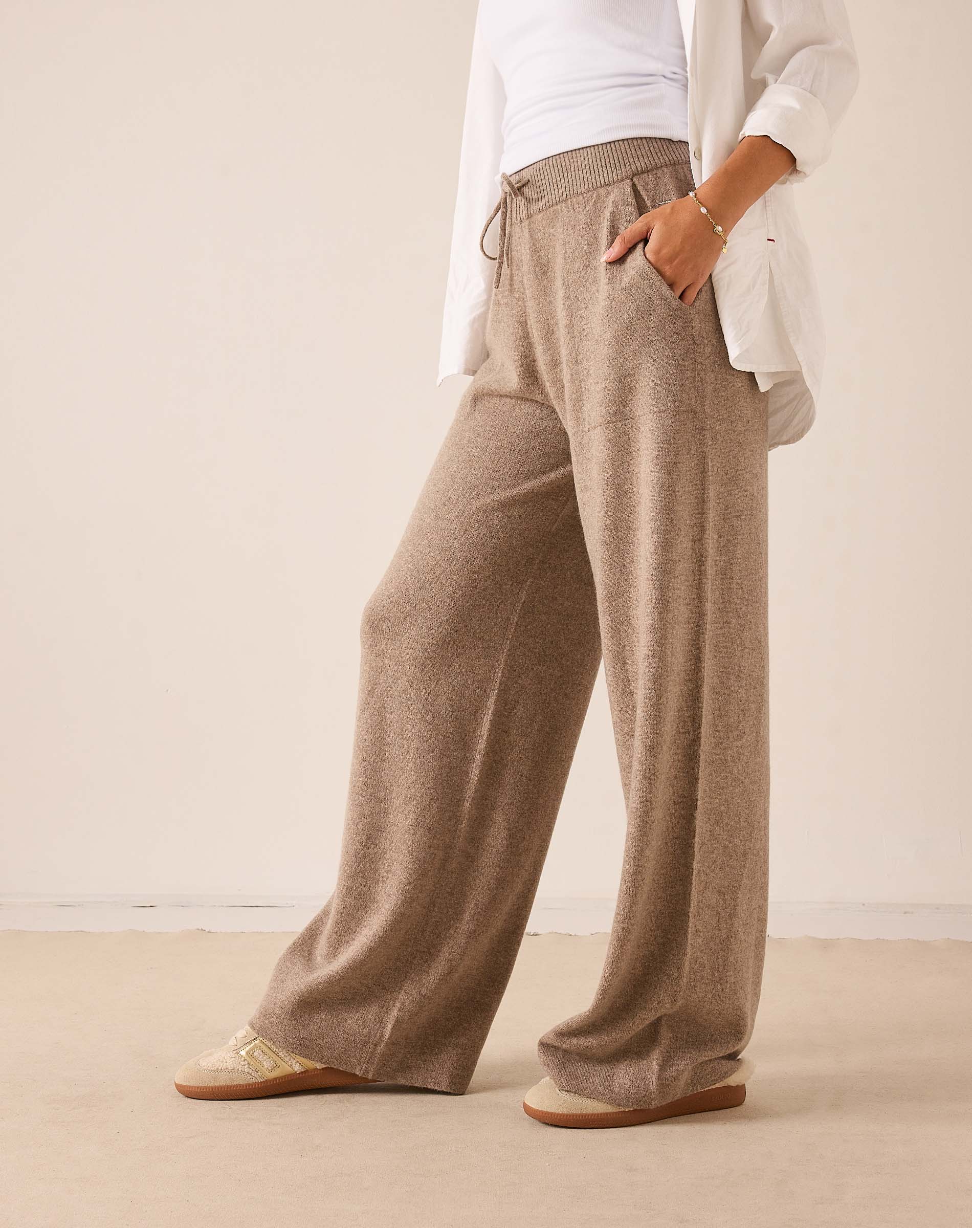 Beige wide-leg cashmere pants with a ribbed waistband and soft knit finish.