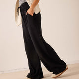 Black wide-leg cashmere pants with a drawstring waist.