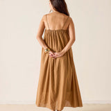 Woman wearing a brown dress against a beige background
