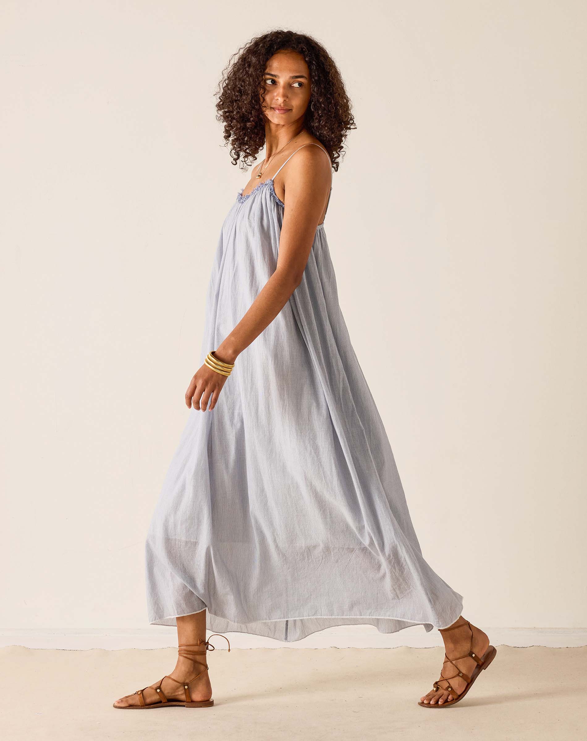 Woman wearing a light blue dress against a plain background