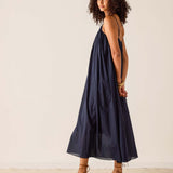 Woman wearing a navy blue dress against a plain background