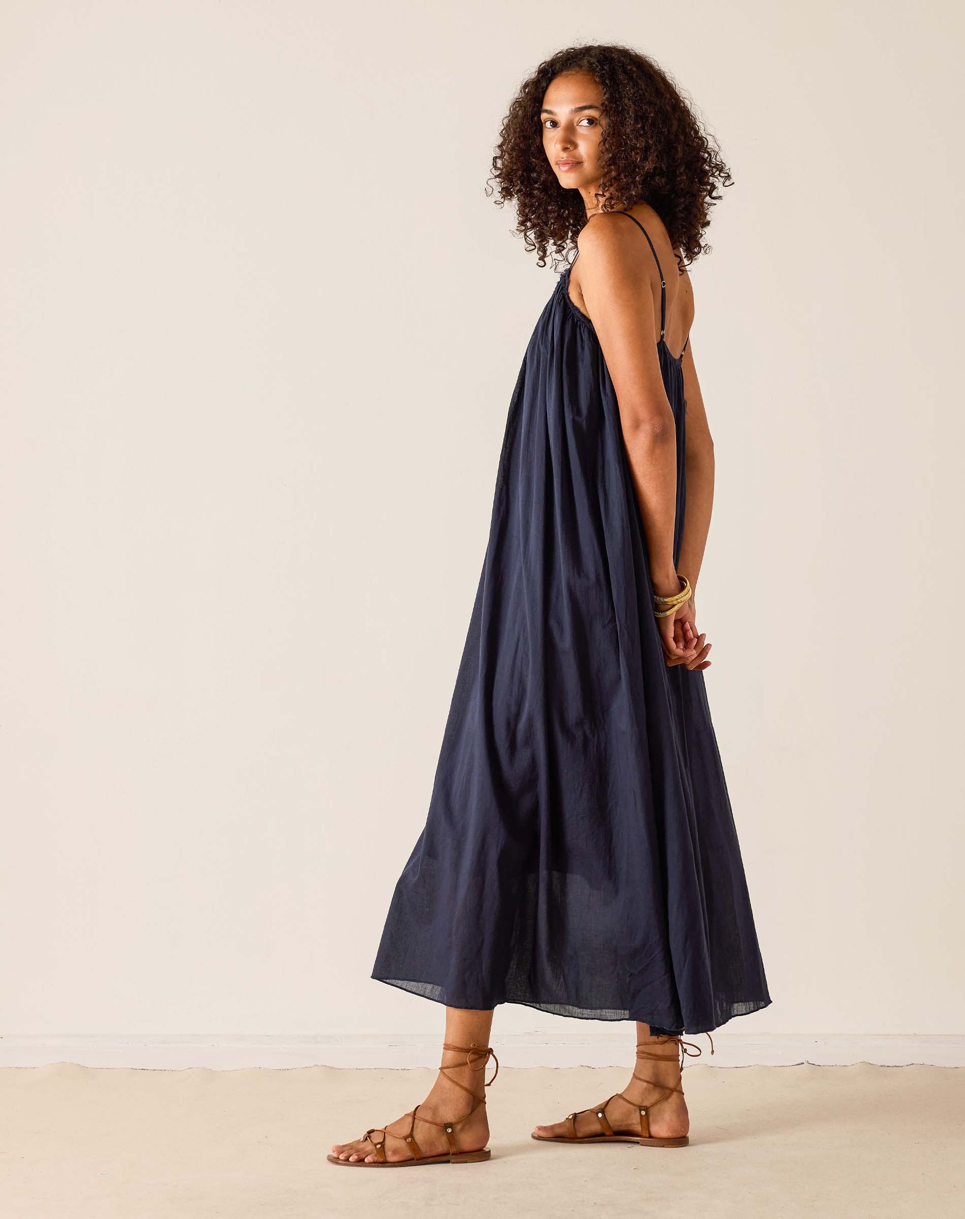 Woman wearing a navy blue dress against a plain background