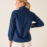 Woman wearing a navy blue shirt with a beige background