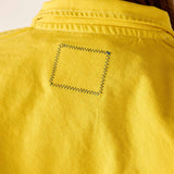 Close-up of a yellow shirt with a pocket detail