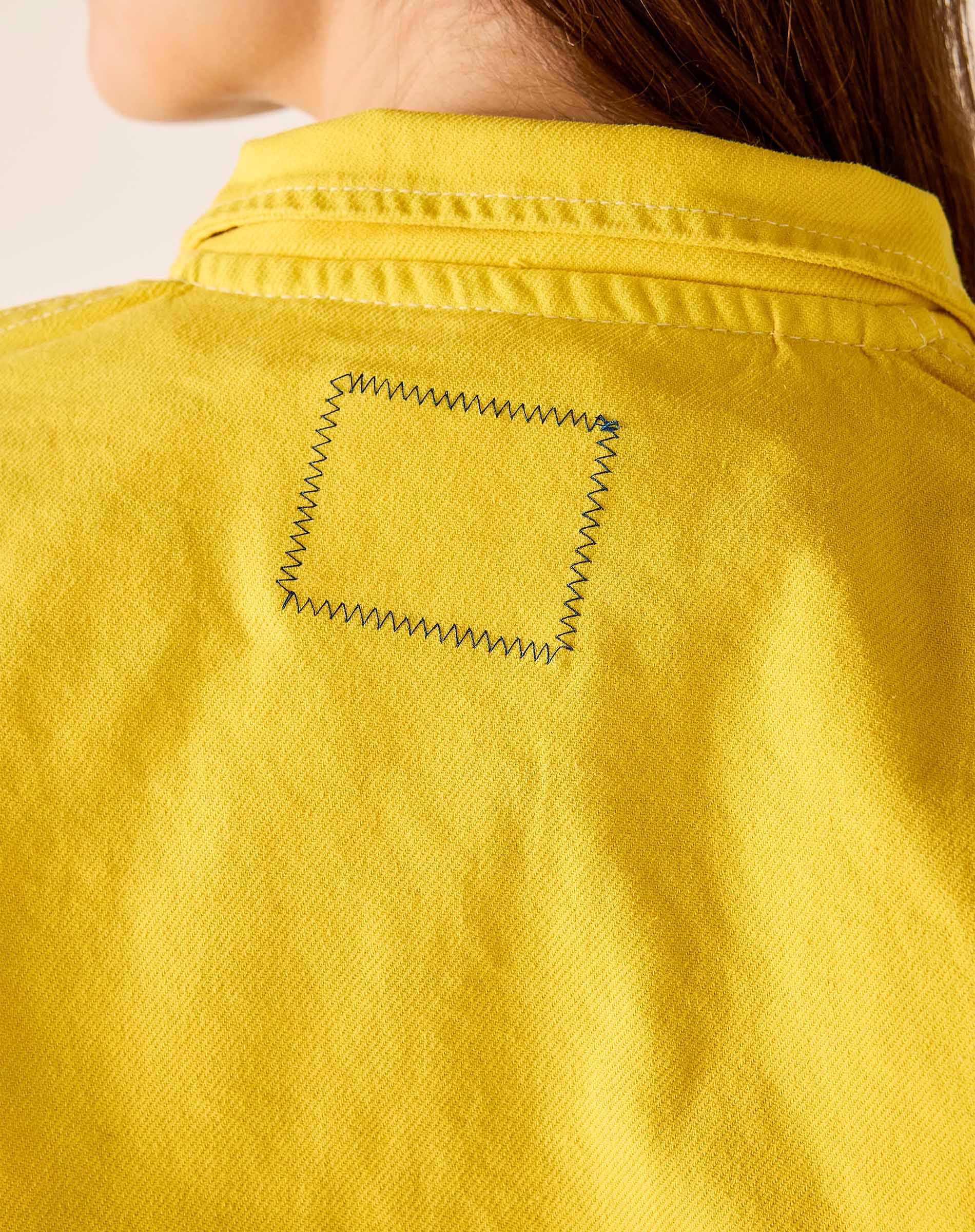 Close-up of a yellow shirt with a pocket detail