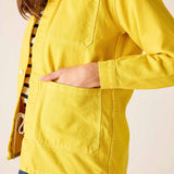 Person wearing a yellow jacket with a neutral background