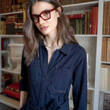 Women's travel-friendly navy blue button-front utility dress with a belted waist and chest pockets.