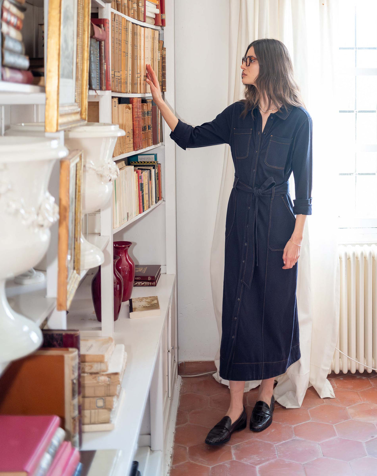Navy blue utility style button-down midi dress with long sleeves and chest pockets.