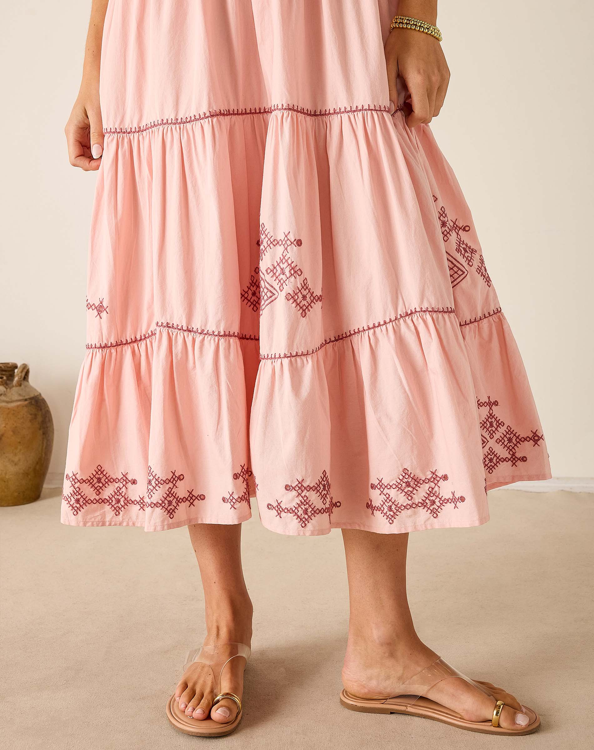 Pink dress with embroidery on a neutral background