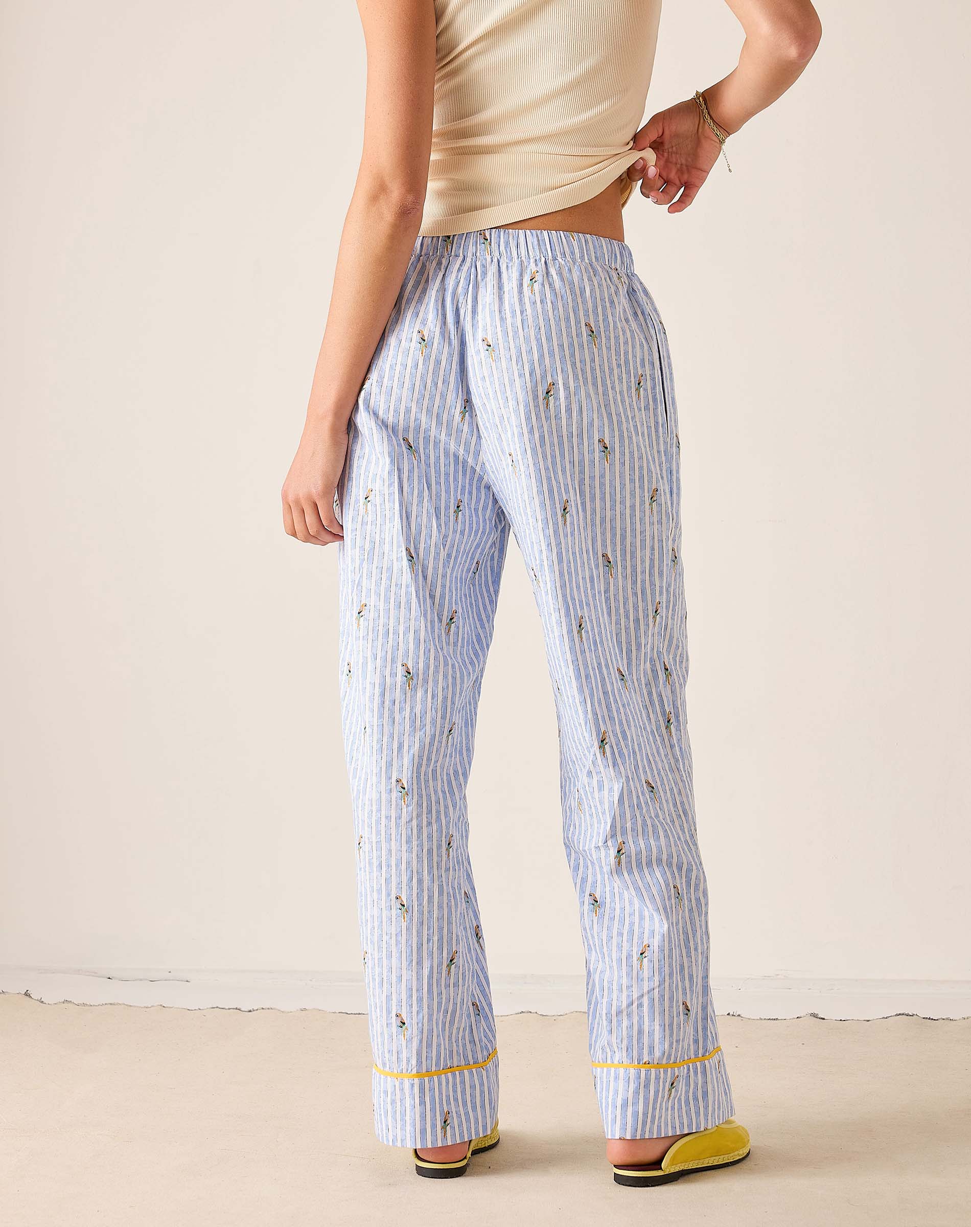 Person wearing light blue striped pajama pants with a subtle pattern on a plain background