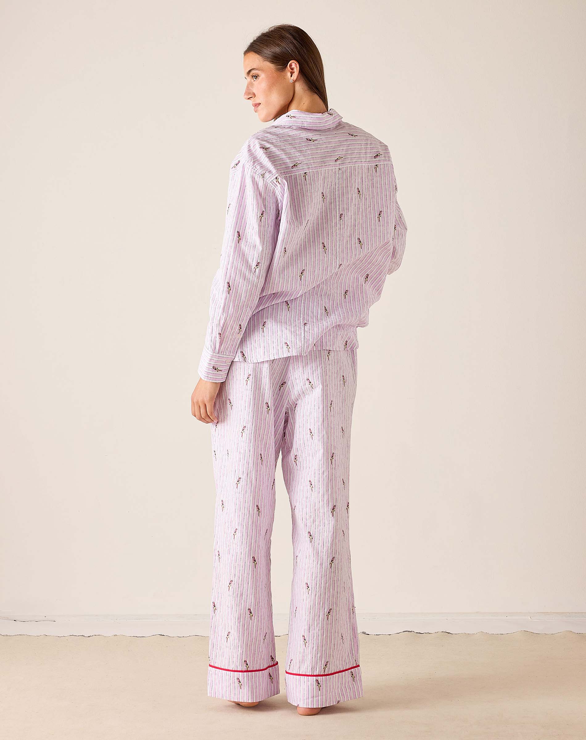 Woman wearing a matching pajama set with a light purple background