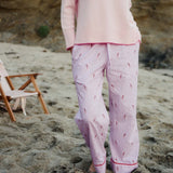 Person wearing pink pajama set on a sandy beach