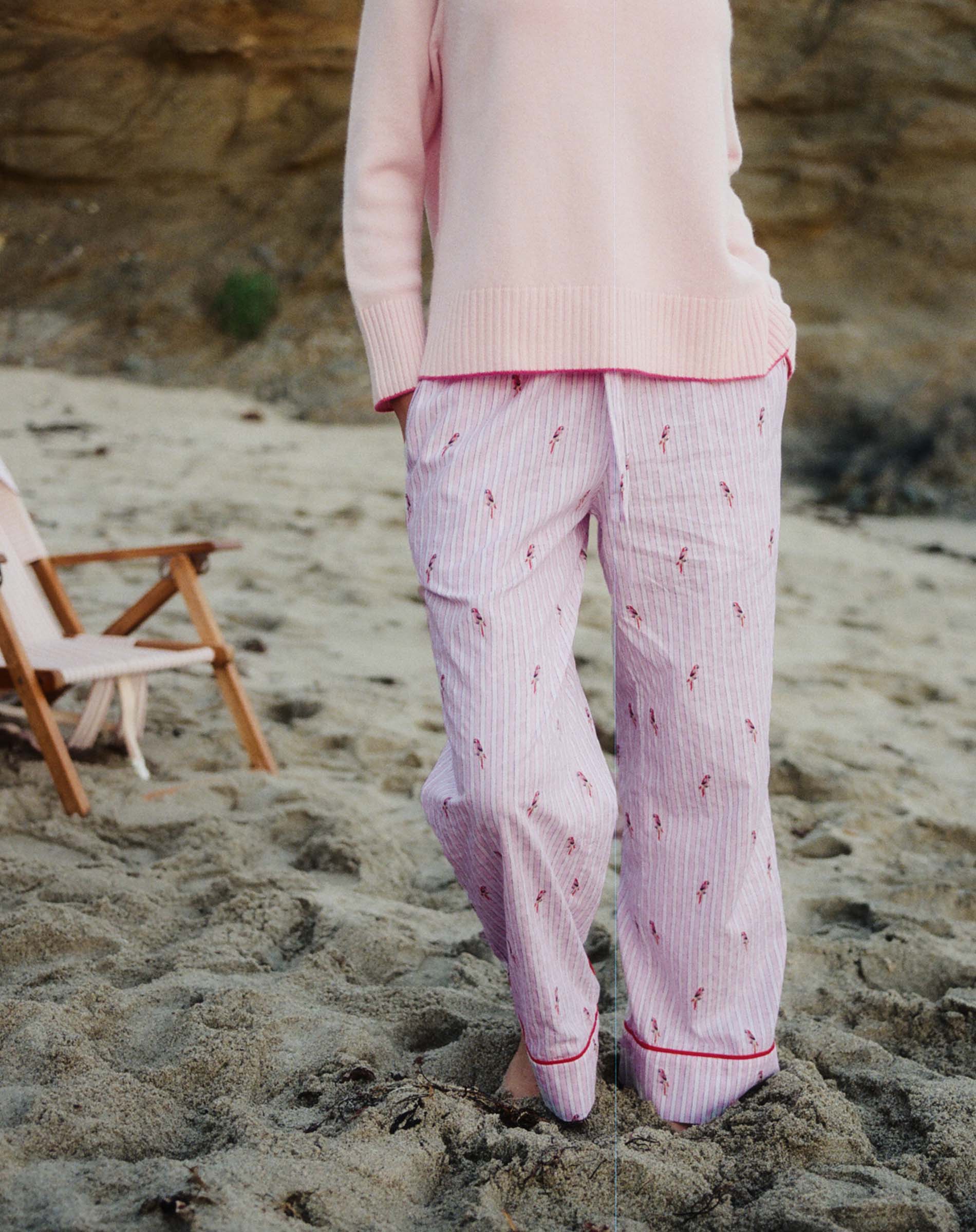Person wearing pink pajama set on a sandy beach
