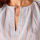 Close-up of a person wearing a striped shirt with a star necklace.