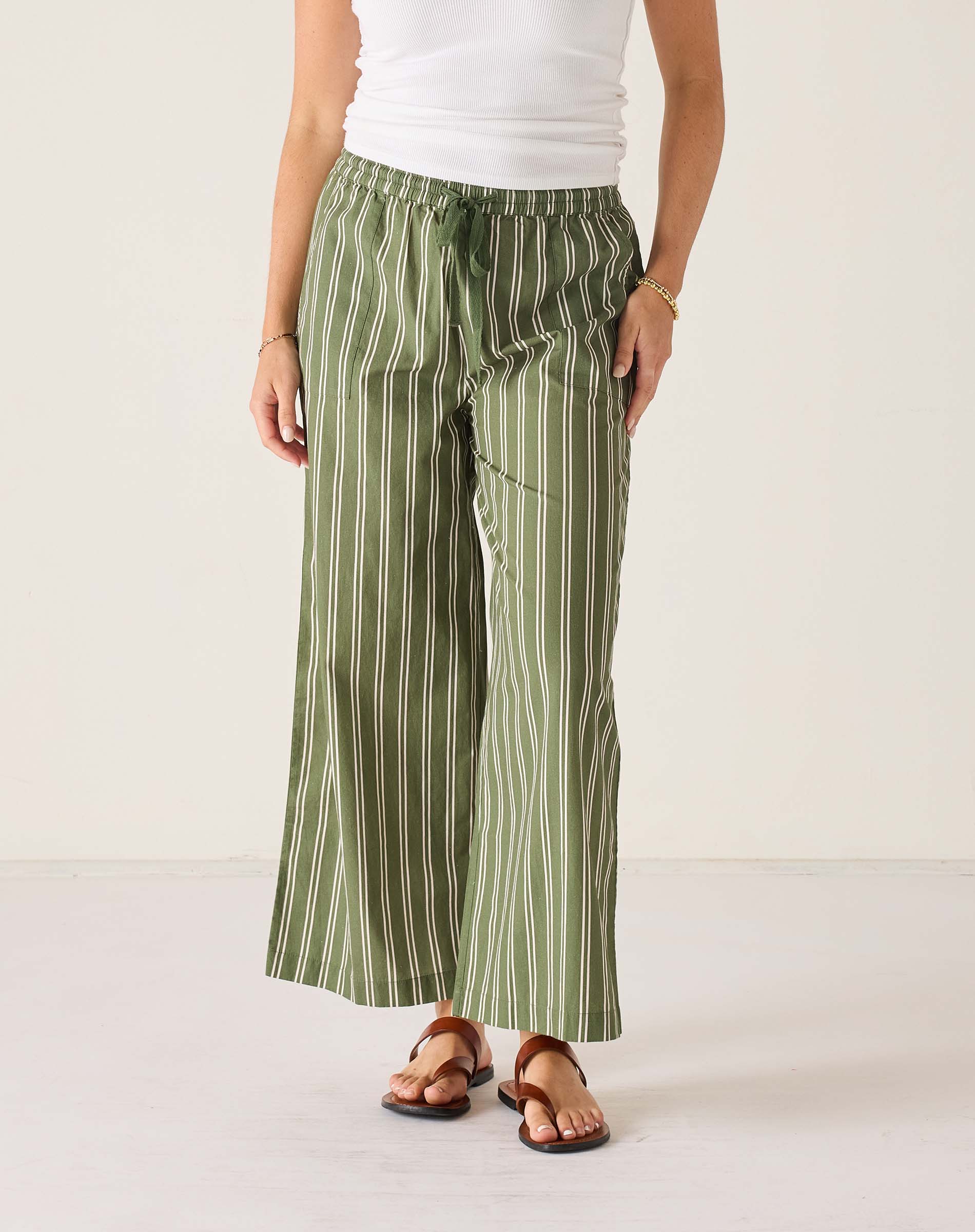 Person wearing green striped pants on a white background