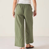 Person wearing green and white striped pants on a plain background