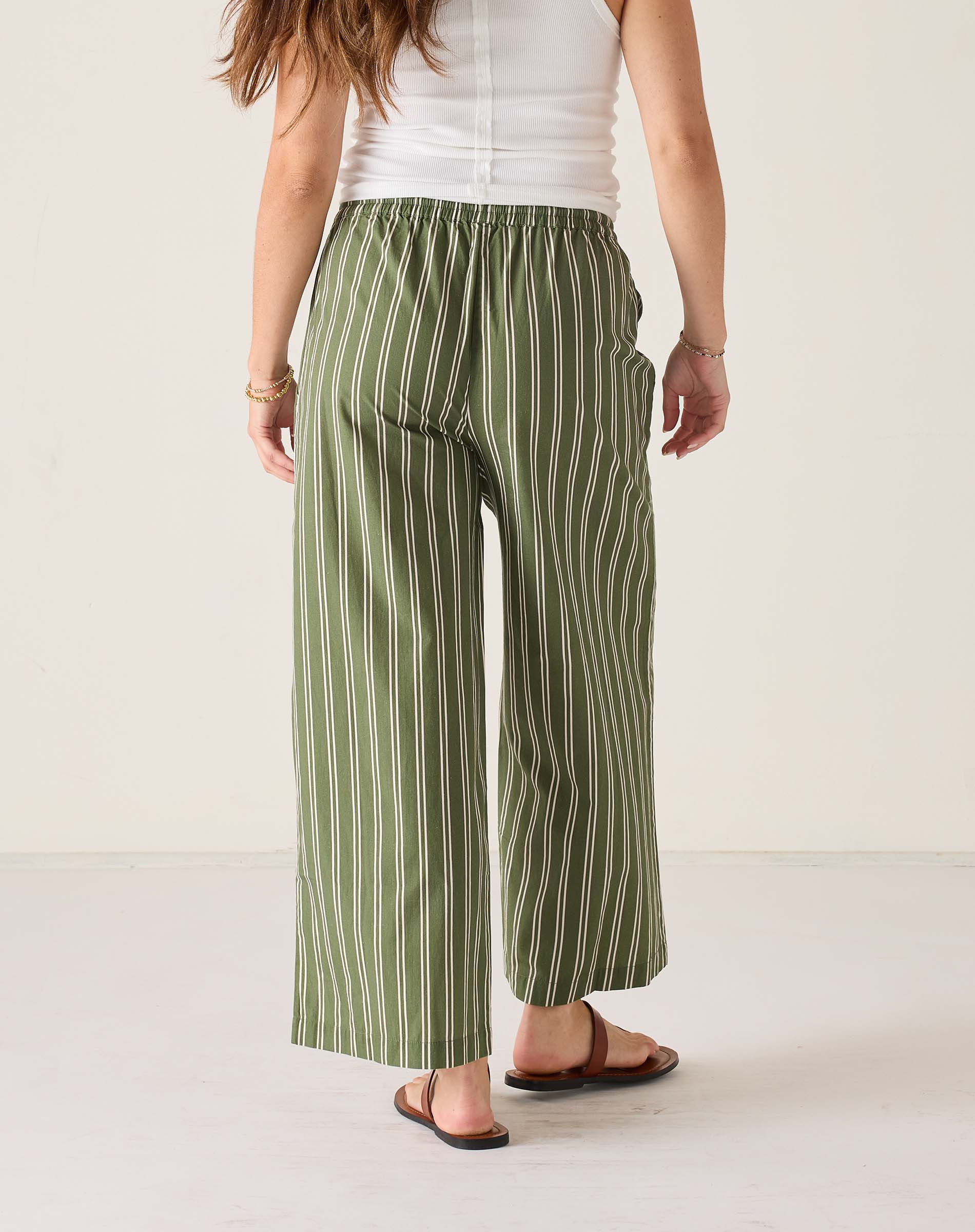 Person wearing green and white striped pants on a plain background