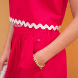 Red outfit with white trim against a yellow background
