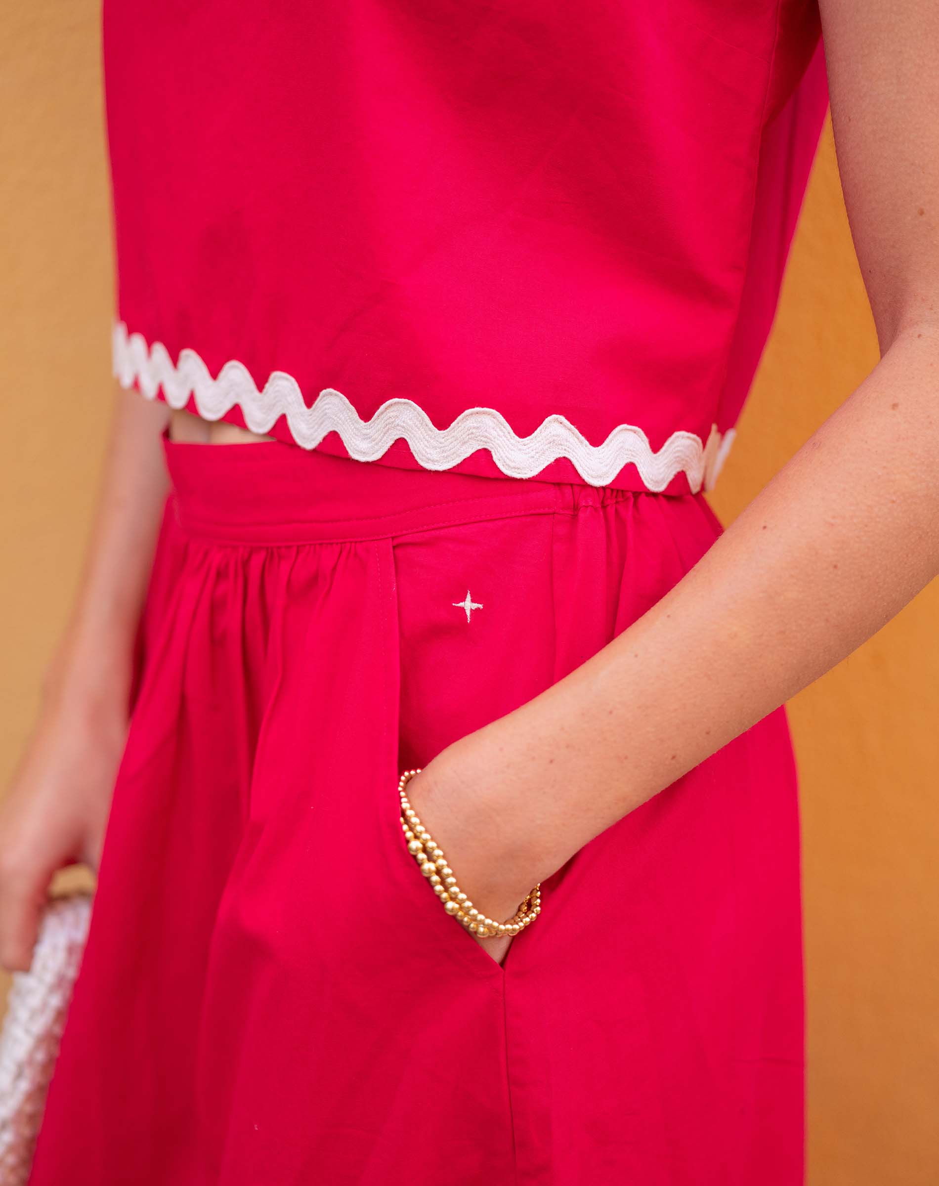Red outfit with white trim against a yellow background
