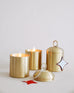 two lit Pumpkin Whimsea Brass Candles next to Pumpkin Whimsea Brass Candle with lid on