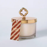 MERSEA women's travel-friendly pumpkin Whimsea candle in a glass jar with a gold lid and an ornate gold handle, featuring a tag that says 'PUMPKIN WHIMSEA' and 'GOLDEN MOMENTS'.
