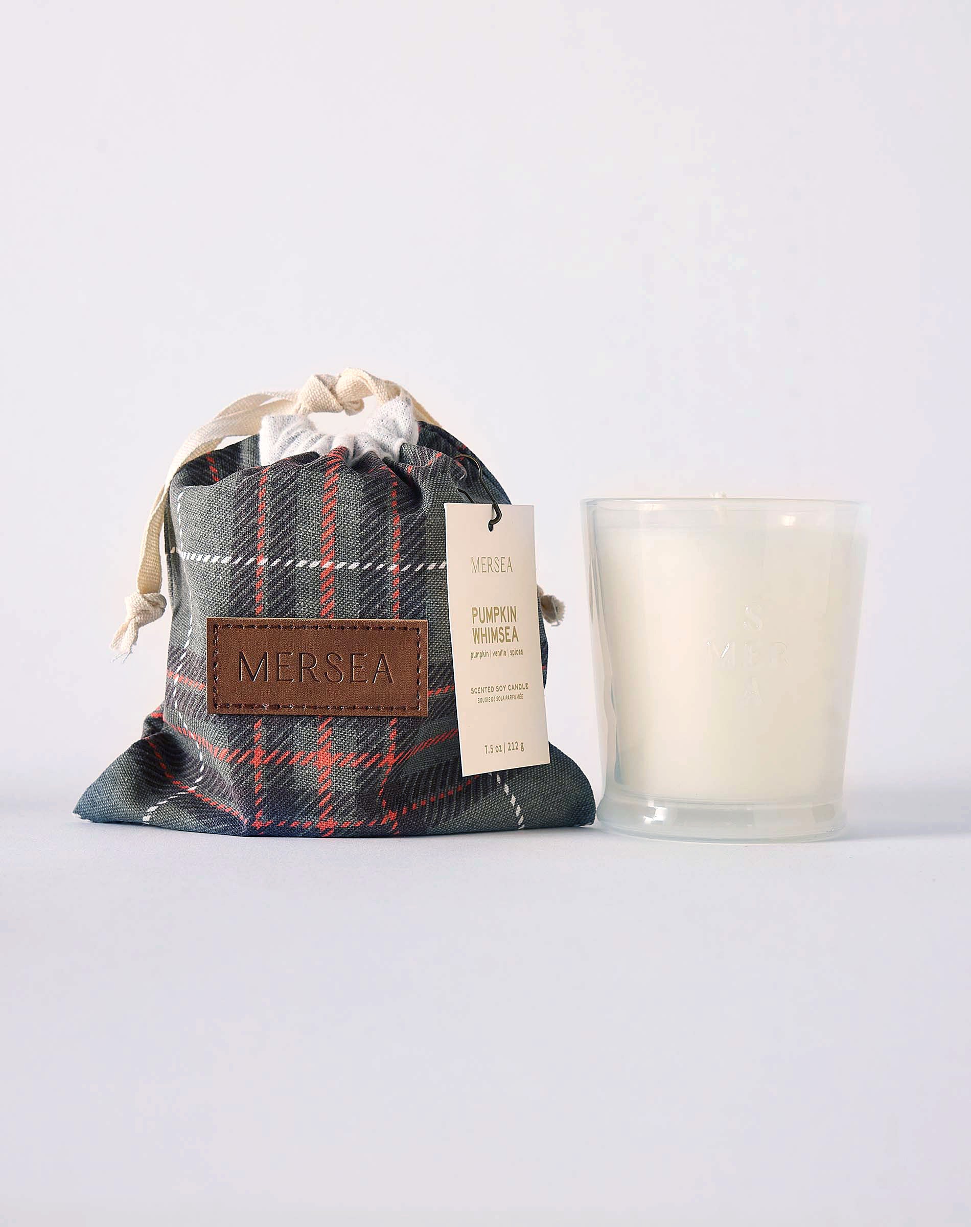 MERSEA ladies' travel-ready pumpkin whimsea plaid drawstring bag and a white candle in a clear glass jar. Text: "MERSEA PUMPKIN WHIMSEA"