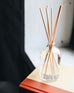 reed diffuser sitting on a book