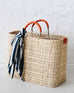 Large Medina market basket with orange handles and details and navy and white stripe scarf wrapped around the handle