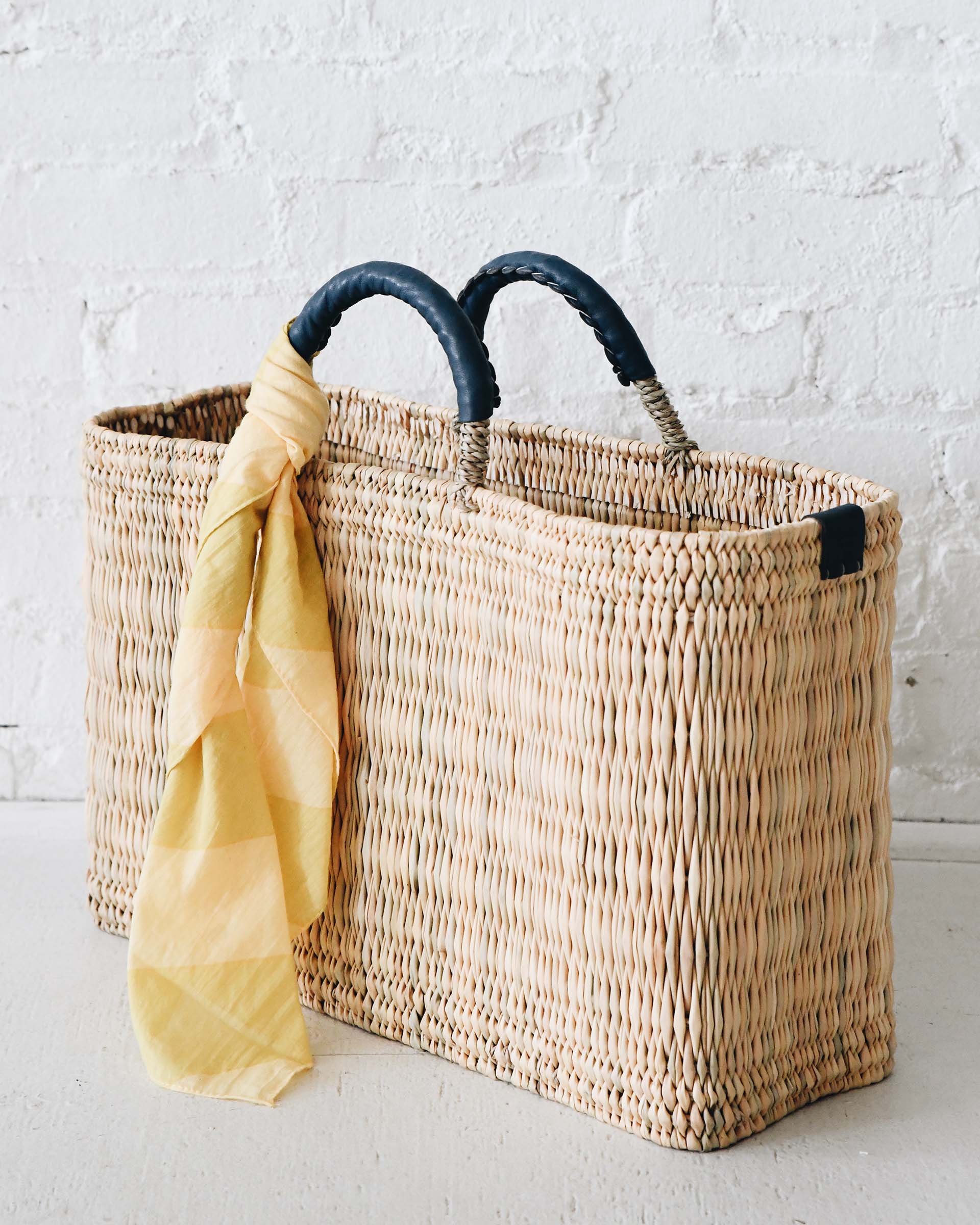 Large Medina market basket with indigo blue handles and details and yellow stripe scarf wrapped around the handle