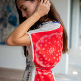 Woman wearing a red and white patterned dress with a blurred background