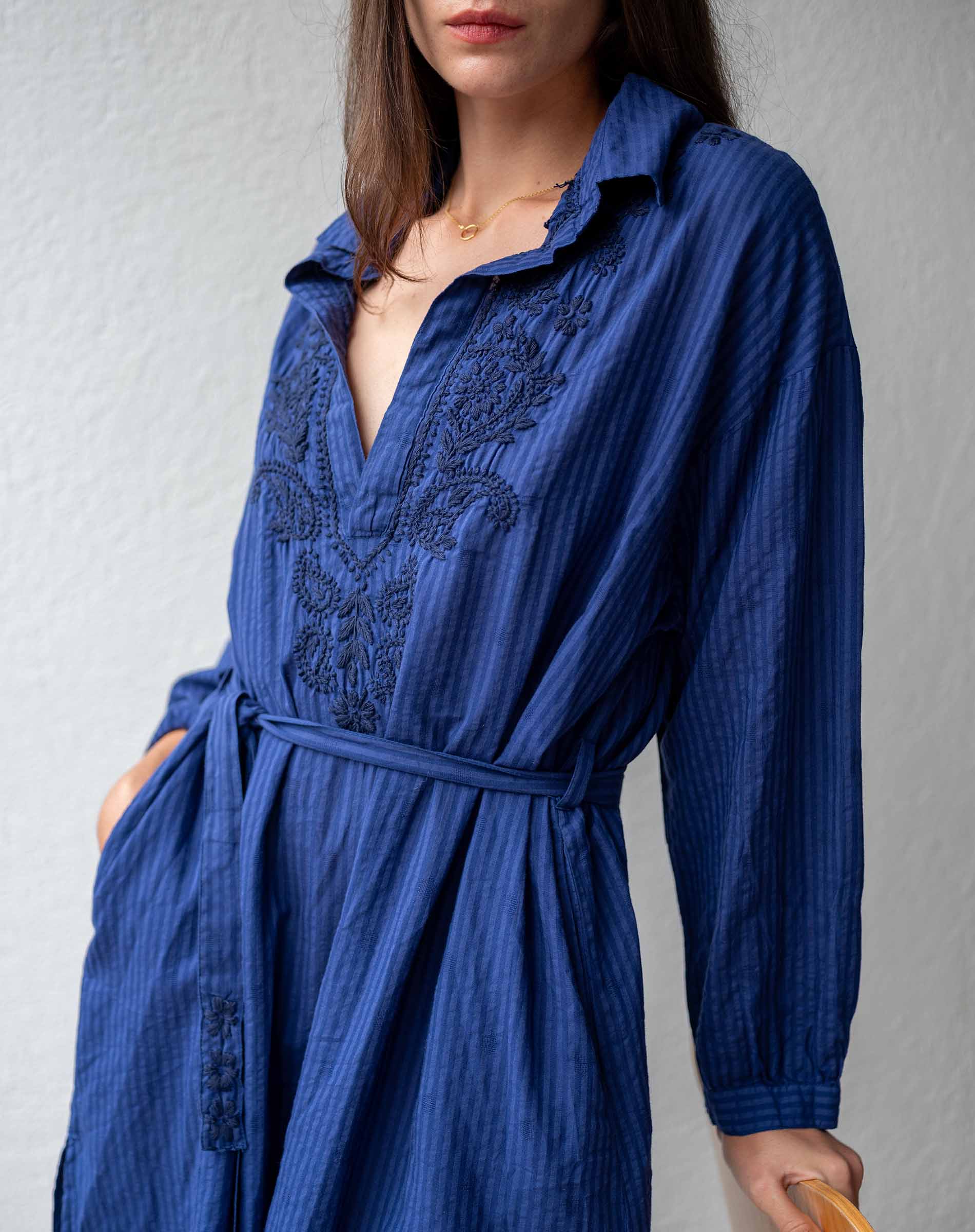 Blue dress with intricate patterns on a plain background