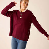 Burgundy oversized knit cashmere sweater with white contrast stitching.