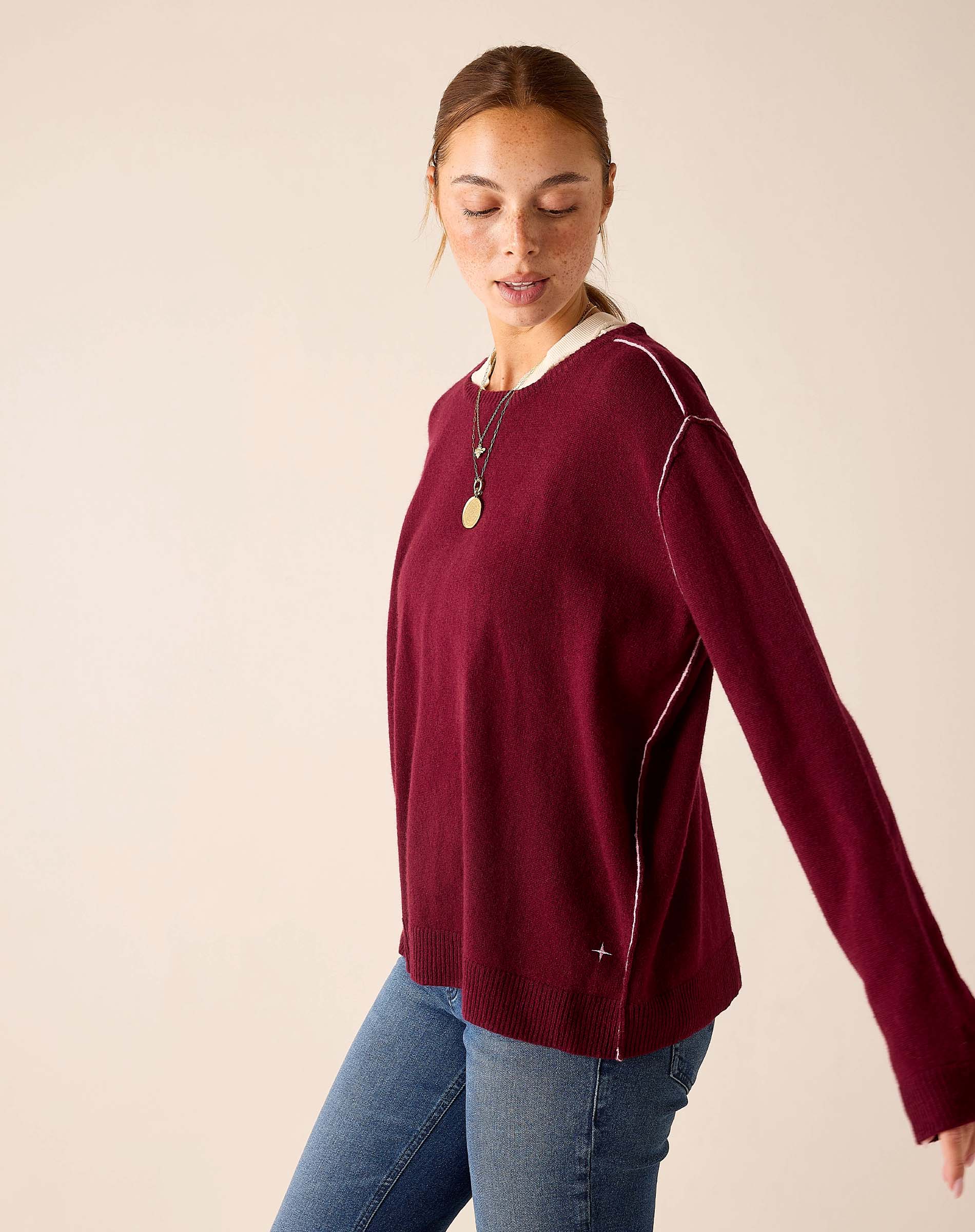 Burgundy barbie cashmere knit sweater with a relaxed boyfriend fit and unique white contrast stitching along the seams.
