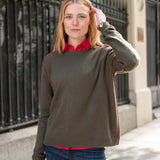 Military green cashmere boyfriend sweater featuring a red trim along the neckline and shoulders.