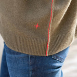Military green cashmere boyfriend sweater with a ribbed hem and contrasting red stitching detail.