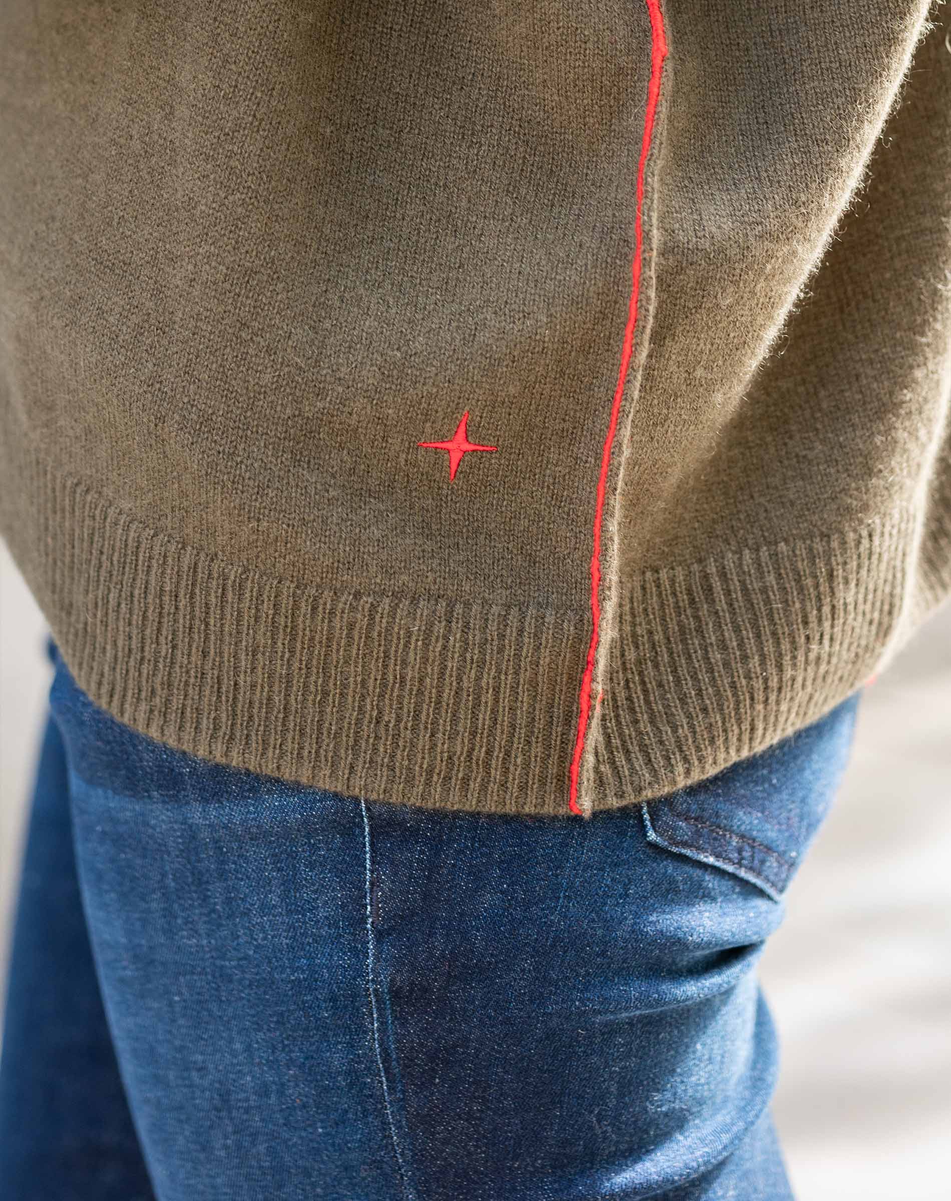 Military green cashmere boyfriend sweater with a ribbed hem and contrasting red stitching detail.