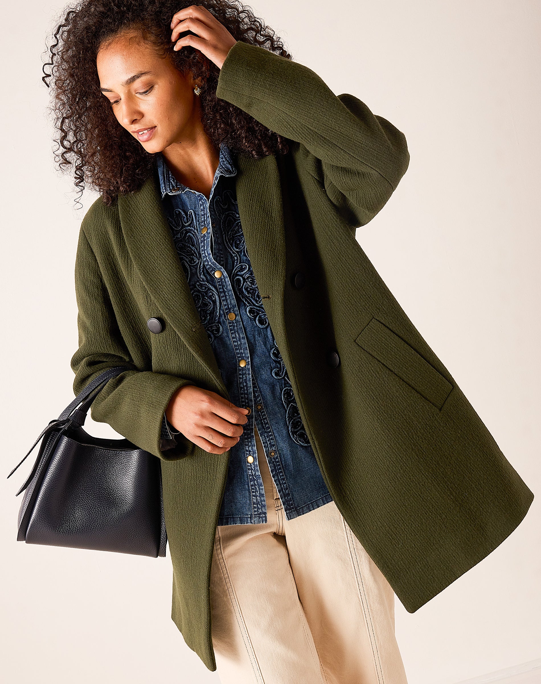 Deep olive oversized wool-blend coat with button details and large pockets.