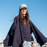 Navy blue knit ruffle wrap with wide sleeves and a cozy layered look.