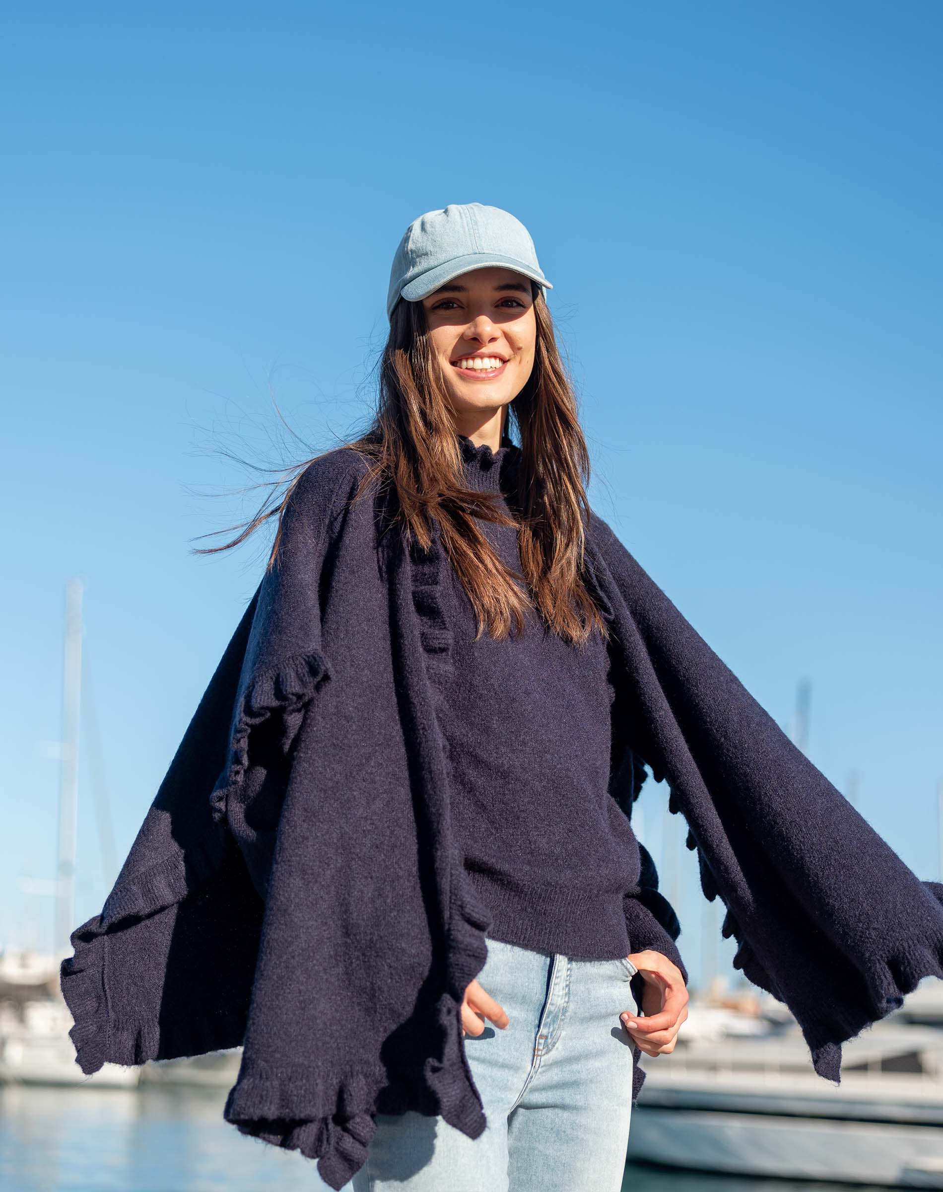 Navy blue knit ruffle wrap with wide sleeves and a cozy layered look.