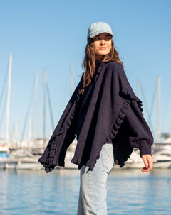 Navy blue ruffled wrap with oversized sleeves and voluminous texture.