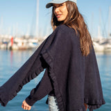Navy blue ruffle wrap with a soft knit texture and ruffled edges.
