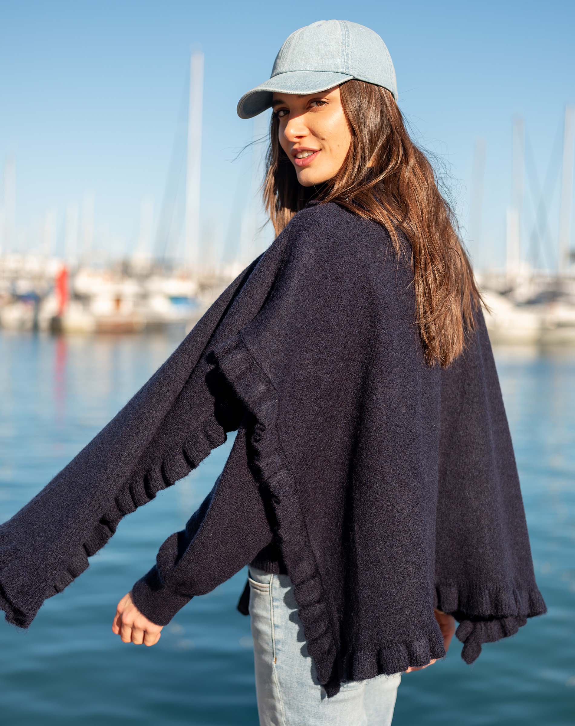 Navy blue ruffle wrap with a soft knit texture and ruffled edges.